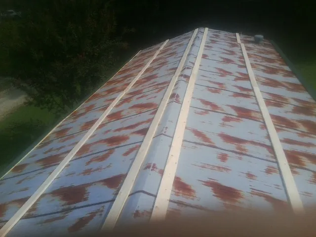 Rusted metal roof panels with new wood purlins before replacement — Storm Damage Roof Repair in Rosine by Roofing Brothers