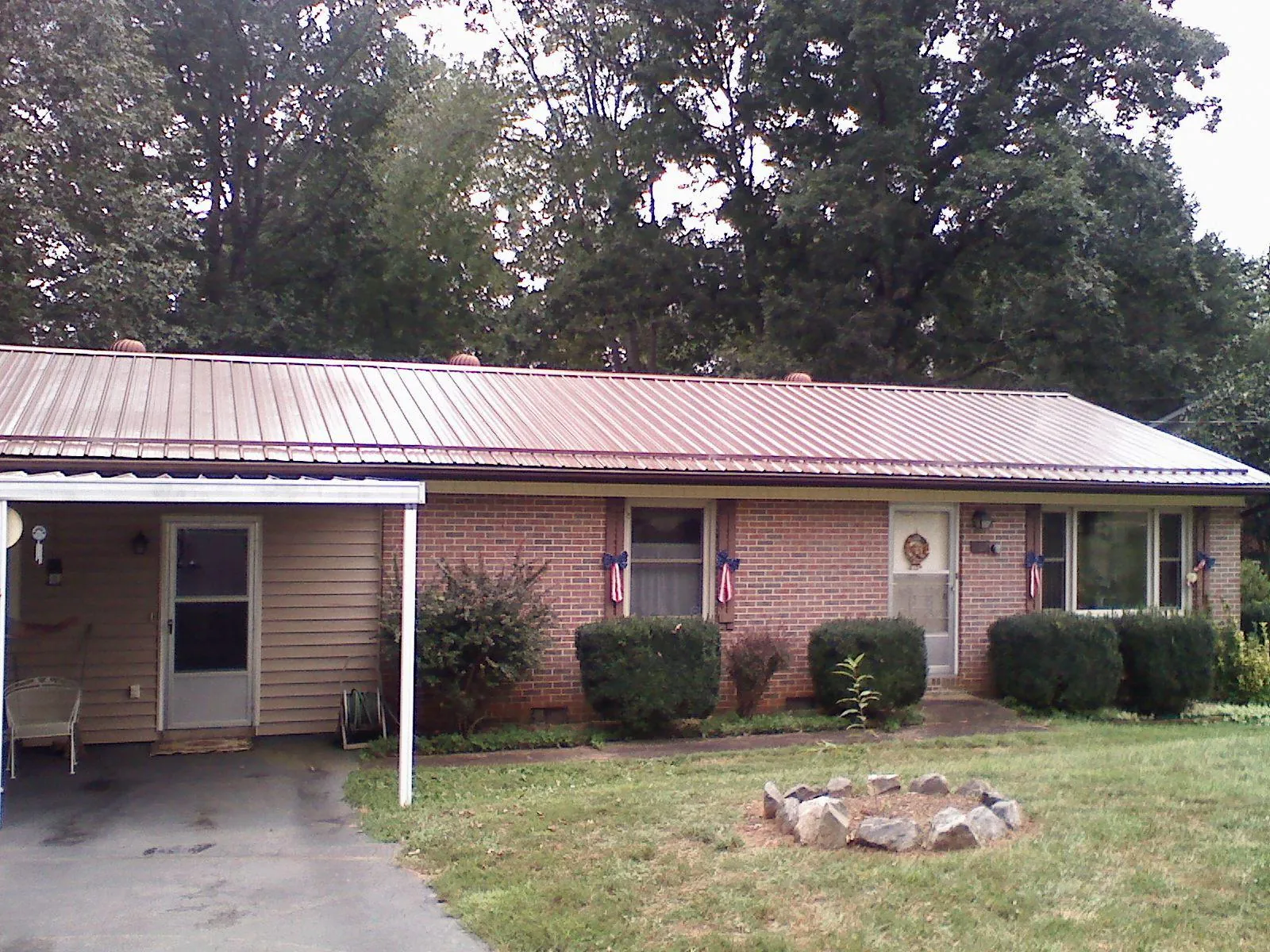 Bronze metal roof and carport on a brick ranch home — Roof Repair work by our crew in Rosine