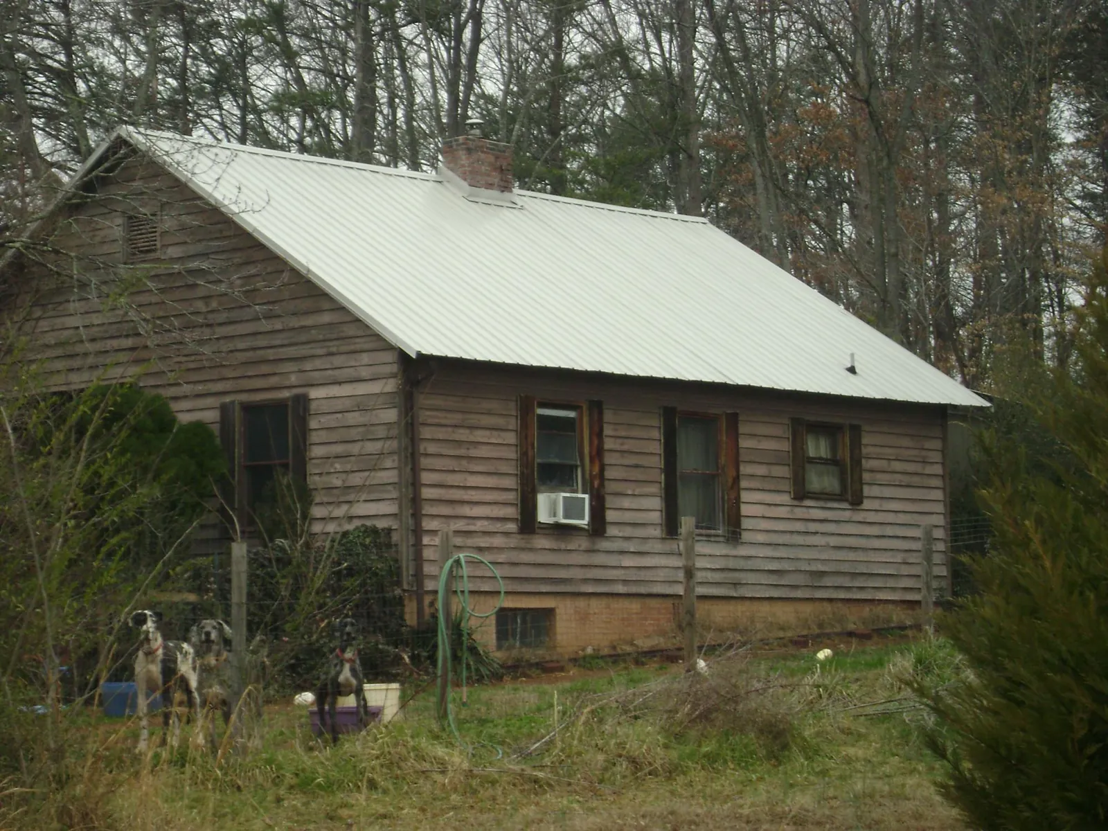 White metal roof on an old wood sided farmhouse, from a Metal Roof Installation job in Rosine